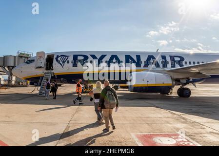 Passagiere, die an einem sonnigen Tag an Bord eines Ryanair Boeing 737-Jet-Flugzeugs gehen, steigen am Flughafen Alicante Elche, Costa Blanca, Spanien, EU, ein. Lichtreflexe Stockfoto