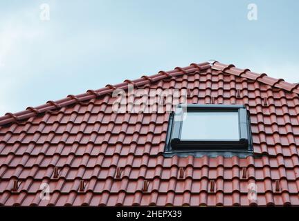 Dachfenster auf roten Keramikfliesen Haus Dach im Freien. Dachfenster Haus Design Ideen Exterieur. Stockfoto