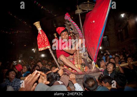 Palanquinenträger eilen inmitten chaotischer Szenen beim Bisket Jatra (Nepalesisches Neujahrsfest) in der UNESCO-Weltkulturerbestadt Bhaktapur, Nepal. Stockfoto