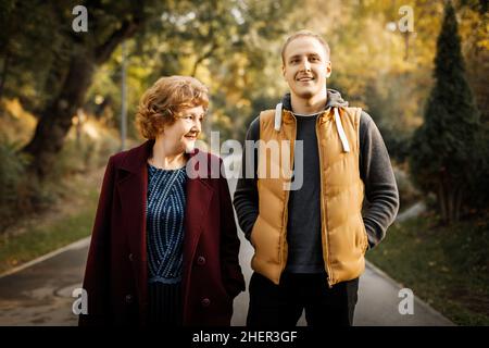 Russische kaukasische reife Mutter mit ihrem erwachsenen Sohn, der im Herbst im Freien läuft. Stockfoto