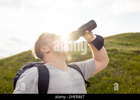 Wanderer trinkt aus seiner Wasserflasche Stockfoto