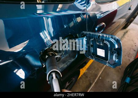 Schlauch an einer Tankstelle in einem metallisch-blauen Auto aus Flüssiggas (LPG)-Kraftstoff angeschlossen. Tanken, Tankstelle, Ökologie, Transport Stockfoto