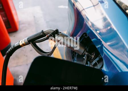 Schlauch an einer Tankstelle in einem metallisch-blauen Auto aus Flüssiggas (LPG)-Kraftstoff angeschlossen. Tanken, Tankstelle, Ökologie, Transport Stockfoto