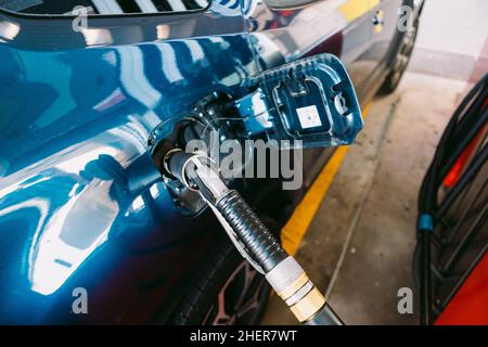 Schlauch an einer Tankstelle in einem metallisch-blauen Auto aus Flüssiggas (LPG)-Kraftstoff angeschlossen. Tanken, Tankstelle, Ökologie, Transport Stockfoto