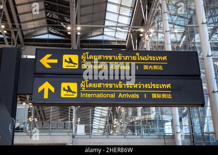 Schild für die Ankunft am Flughafen. Fluginformationen am Flughafen in englischer, chinesischer und thailändischer Sprache Stockfoto