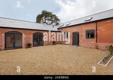 Cowlinge, Suffolk, England - 28. März 2019: Stilvoller Umbau der Scheune nach hinten mit weitläufiger Ziegelfassade, Schindelgärten, neuer Gewinn Stockfoto