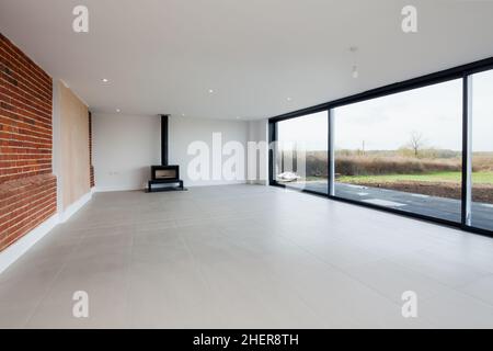 Cowlinge, Suffolk, England - 28. März 2019: Gut proportionierter Lounge- und Wohnbereich in Scheune Coversion mit original Ziegelwand, gefliestem Flo Stockfoto