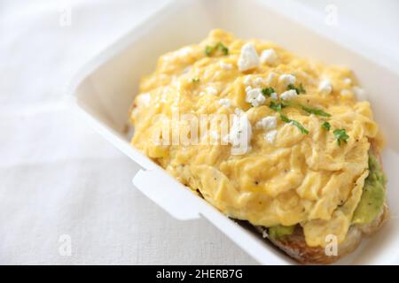 Avocado und Rühreier Toast mit Lieferpaket auf weißem Hintergrund Stockfoto