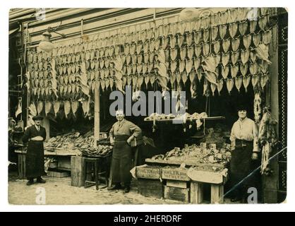 Originalfoto aus dem frühen 20. Jahrhundert aus der Zeit WW1 von Fischhändlern, Fischfilets, die vor dem Laden aufgehängt wurden, Kisten mit Schalentieren aus Newyln, Cornwall, in Holzkisten vor dem Stand in der Gegend von Lavender Hill in London, Großbritannien, um 1914-1918. Stockfoto