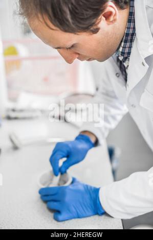 Der Chemiker führt ein Experiment mit flüssigem Stickstoff im Labormörtel mit Stößel durch Stockfoto