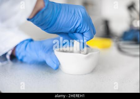 Der Chemiker führt ein Experiment mit flüssigem Stickstoff im Labormörtel mit Stößel durch Stockfoto