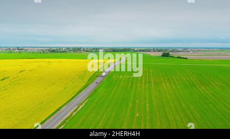 Luftaufnahme Der Highway Road Durch Feld Und Sommer Weizenfelder Landschaft. Draufsicht Auf Die Prime Mover-Antriebseinheit Des Lkw-Traktors In Bewegung Ein Stockfoto