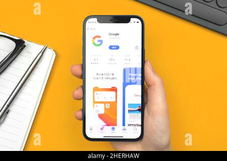 Charkow, Ukraine - 10. Januar 2022: Google App. Frau verwendet die Anwendung auf dem Apple iPhone 12 mini Stockfoto