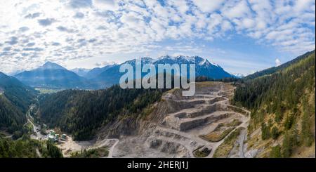 Luftpanorama zum Steinbruch bei weissenbach in tirol mit bewölktem Himmel und Bergen Stockfoto