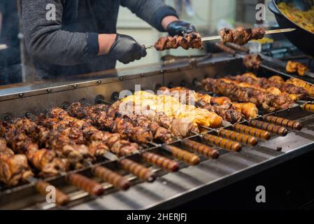 Der Verkäufer frittiert Fleischkebabs auf dem Festival. Street Fast Food Stockfoto