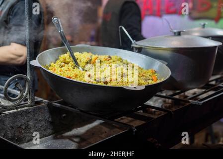 Plov Gericht mit Fleisch in einem Kessel gekocht. Street Food. Stockfoto