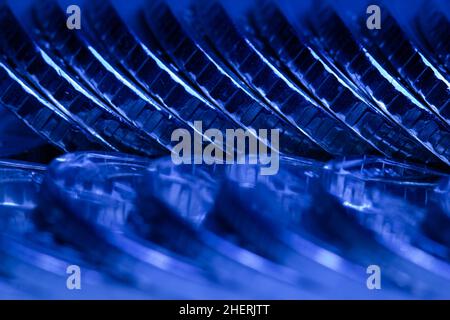 Viele Metallmünzen hintereinander im dunkelblauen Licht. Schöner Geldhintergrund. Hintergrund der Münzen. Finanzkonzept. Geschäftskonzept. Bild Stockfoto