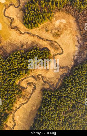 Luftaufnahme eines Flusses, der sich durch die ländliche Landschaft schlängelt. Flußtal von einer Drohne geschossen. Stockfoto