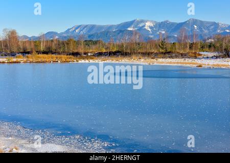 Gefrorener Moorteich mit Raureif, Chiemgauer Alpen im Hintergrund, Grundbeckenmoor bei Rosenheim, Bayern, Deutschland Stockfoto