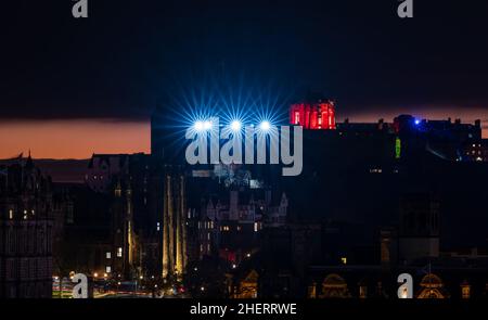 Eine Lichtshow vom Edinburgh Castle über der Skyline der Stadt mit einem farbenfrohen orangefarbenen Sonnenuntergang, Edinburgh, Schottland, Großbritannien Stockfoto