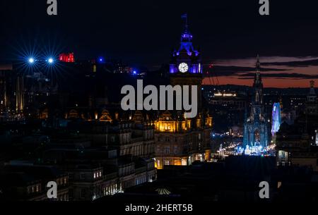 Eine Lichtshow vom Edinburgh Castle aus, die bei Sonnenuntergang und weihnachtlichen Festlichtern über der Skyline der Stadt zu sehen ist, Edinburgh, Schottland, Großbritannien Stockfoto