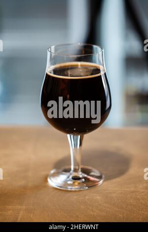 Ein Glas des russischen kaiserlichen Stout Craft Beer auf Holzoberfläche Stockfoto