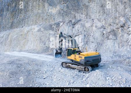 Riesiger schwerer Grabungsgrubber mit Schaufel am Kalksteinsteinbruch Stockfoto