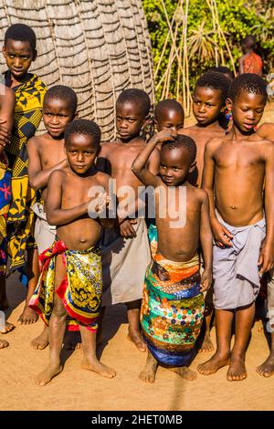 Kinder beobachten mit Interesse die traditionellen Bräuche in einem echten afrikanischen Dorf, Umphakatsi Chief Stockfoto