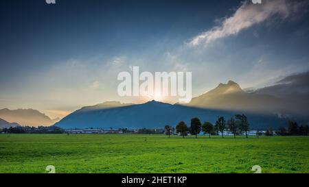 Volumen Lichtstrahlen der Sonnenuntergangssonne hinter dem Gipfel der Bergkette in österreich Urlaub Stockfoto