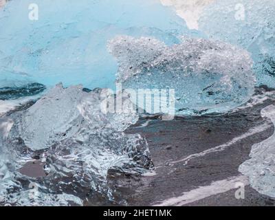 Während des Sonnenuntergangs funkeln unglaubliche Teile des Eisbergs am berühmten Diamond Beach in der Jokulsarlon Lagune Stockfoto