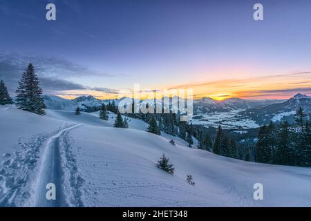 Farbenfrohe Sonnenuntergänge von der Skipiste auf verschneiten Bergen im Winter Stockfoto