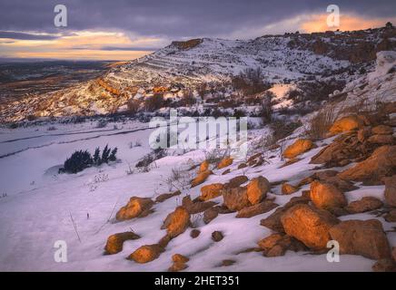 Wunderschöner farbenprächiger Sonnenuntergang in einem verschneiten Berg Stockfoto