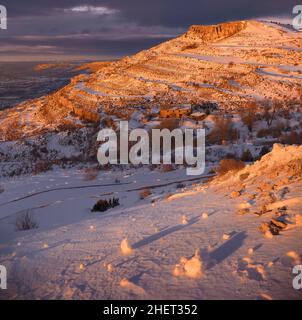 Wunderschöner farbenprächiger Sonnenuntergang in einem verschneiten Berg Stockfoto