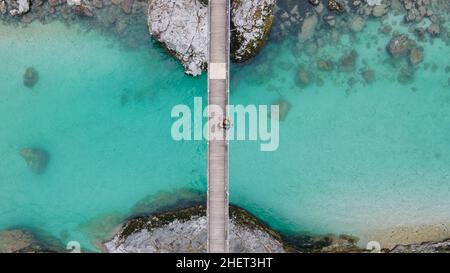 Schönes Paar, das auf einer Brücke über den kristallblauen Soca-Fluss, Slowenien, zusammensteht Stockfoto