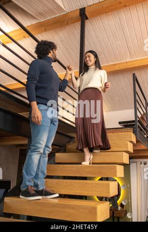 Ansicht von unten, wie eine Frau zum Mann die Treppe hinunter ging Stockfoto