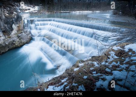 Fließendes Wasser über Stufen des Flusses fallen im Winter in bayern Stockfoto