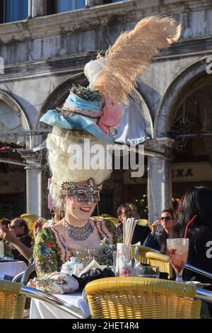 Frau in bunten historischen Rokoko-Kostüm und Hüten in Café auf dem Markusplatz, Karneval in Venedig, Carnevale di Venezia, Italien Stockfoto