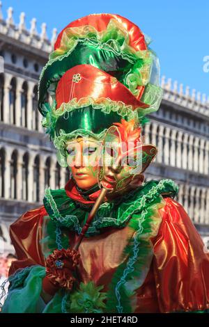 Frau in bunten historischen venezianischen Phantasie Kleid Kostüm. hut und Maske, poseon Piazza San Marco, Karneval von Venedig, Carnevale di Venezia, Italien Stockfoto