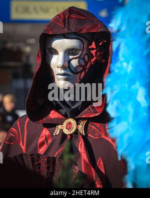 Frau in Maske und Umhang, historisches Kostümkostüm schaut vor die Kamera, an Karneval in Venedig, Carnevale di Venezia, Italien Stockfoto