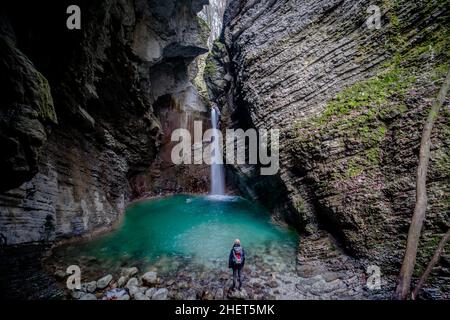 Person, Rucksacktourist, der vor dem Wasserfall Kozjak im Triglav Nationalpark, Slowenien, steht Stockfoto