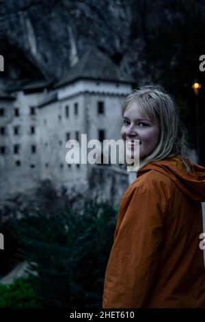 Junge weibliche Mädchen, lachende Frauen vor dem Schloss Predjama - Predjamski Grad im Frühjahr, Slowenien Stockfoto