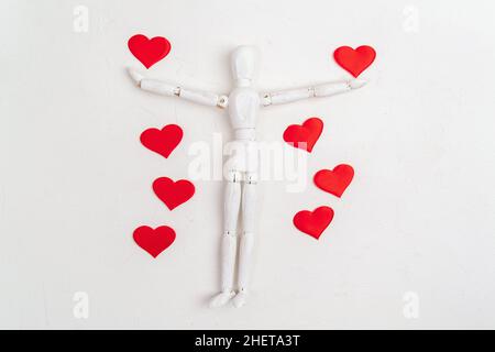 Hölzerne Mann Herz Figur auf weißem Hintergrund. Schaufensterpuppe aus Holz. Valentinstag-Konzept. Stockfoto