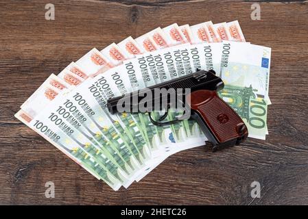 Die Pistole von Makarov liegt auf Euro- und Rubel-Banknoten. Kriminelles Konzept. Stockfoto