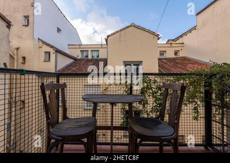 Kleine Terrasse mit Weinreben und einem Holztisch und Stühlen zum Entspannen Stockfoto