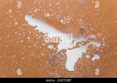 Verschüttete Milch, Flüssigkeit, Schmutz und Pfütze auf dem Boden. Stockfoto