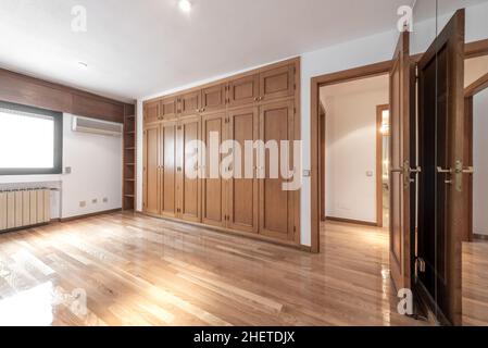 Zimmer mit großem Einbauschrank aus Eichenholz und Eichenparkettböden mit Klimaanlage und Heizung Stockfoto