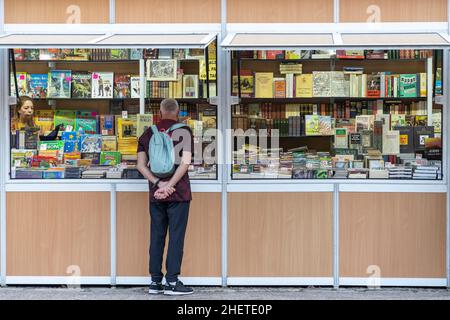 ALCALA DE HENARES, MADRID, SPANIEN - 10. OKTOBER 2019: Mann, der sich die Bücher an einem Stand auf der alten und gelegentlichen Buchmesse in alcala de henare ansieht Stockfoto