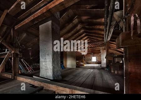 Altes Dachgeschoss aus Holz mit Dachkonstruktion und Fenster Stockfoto