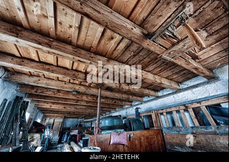 Alter Lagerraum mit Schrott und Holzdecke Stockfoto