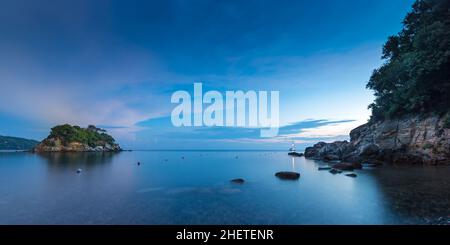 Kleine Insel bei Sonnenaufgang mit steinerner Küste auf elba italien Stockfoto